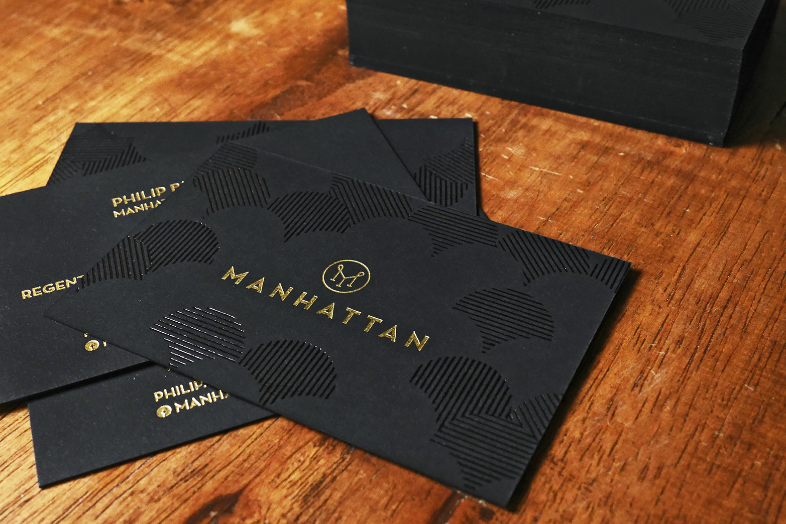 A custom media kit in Singapore containing matte black business cards with golden accents